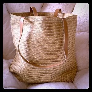 Tan straw tote bag with leather handles